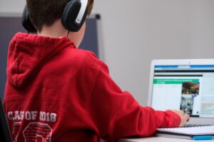 Boy working at computer with headphones. 